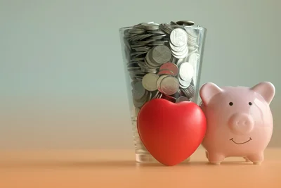 Prasiatko pokladnička, srdiečko a nasporene mince v pohari