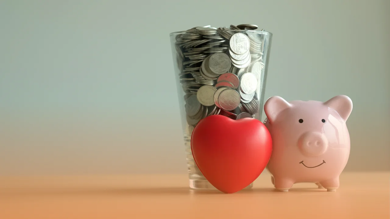 Prasiatko pokladnička, srdiečko a nasporene mince v pohari